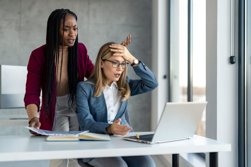 Two women having problems with laptop system